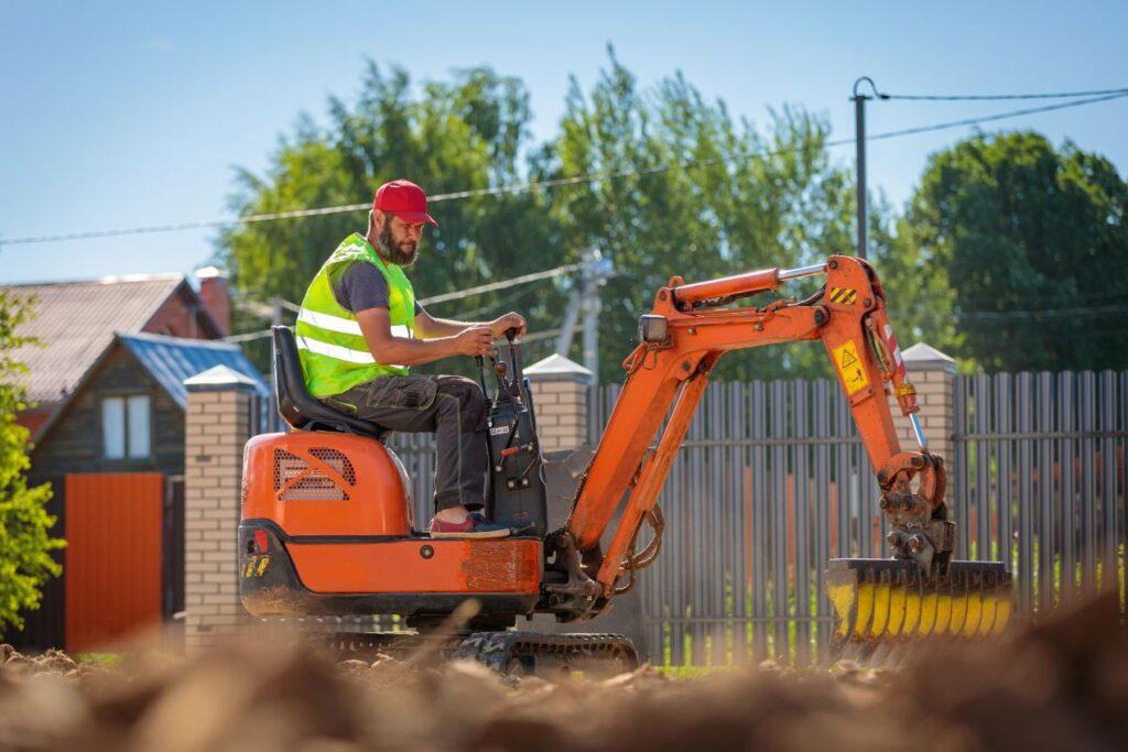 Minibagger Schaufel im Einsatz auf privater Baustelle bei Erdarbeiten in Wohnsiedlung