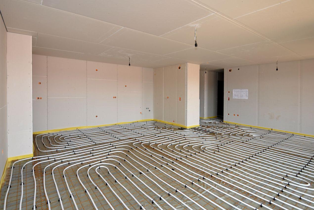 Offener Raum mit frisch verlegten Heizrohren zeigt die Installation einer Fussbodenheizung fraesen fuer gleichmaessige Waermeverteilung